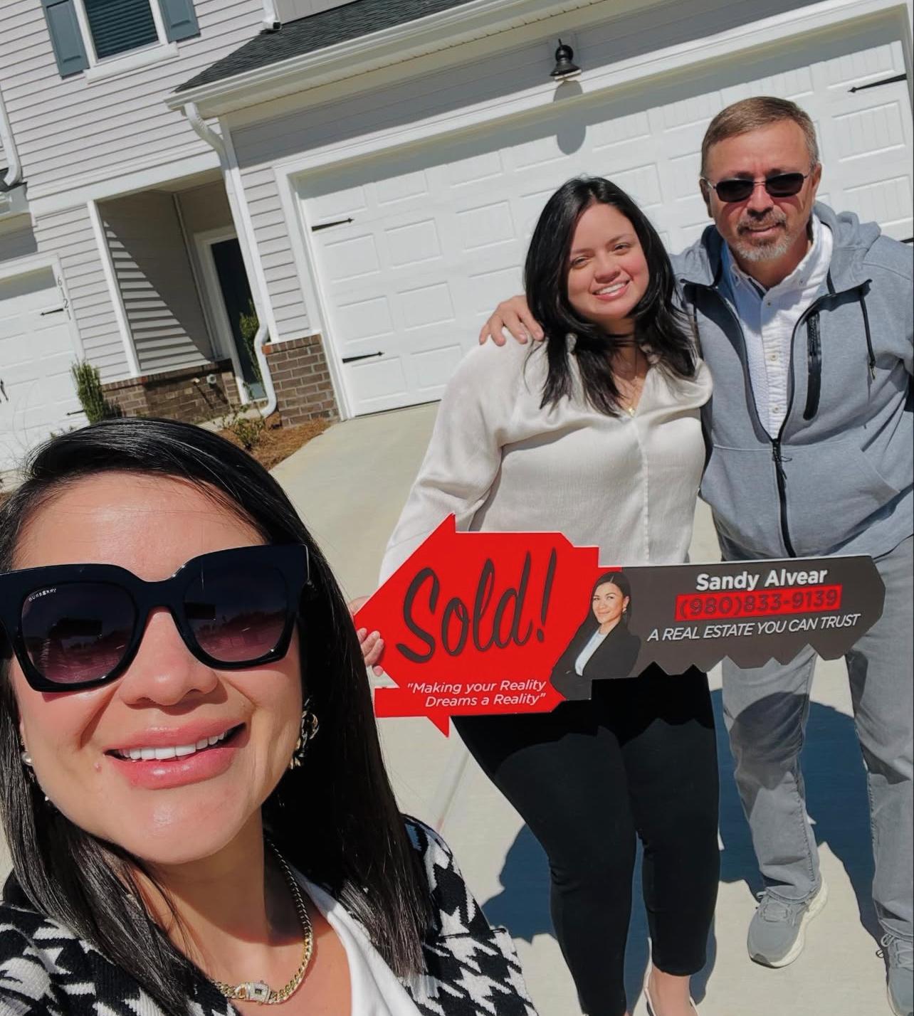 Sandy Alvear selfie with clients at new construction sold home